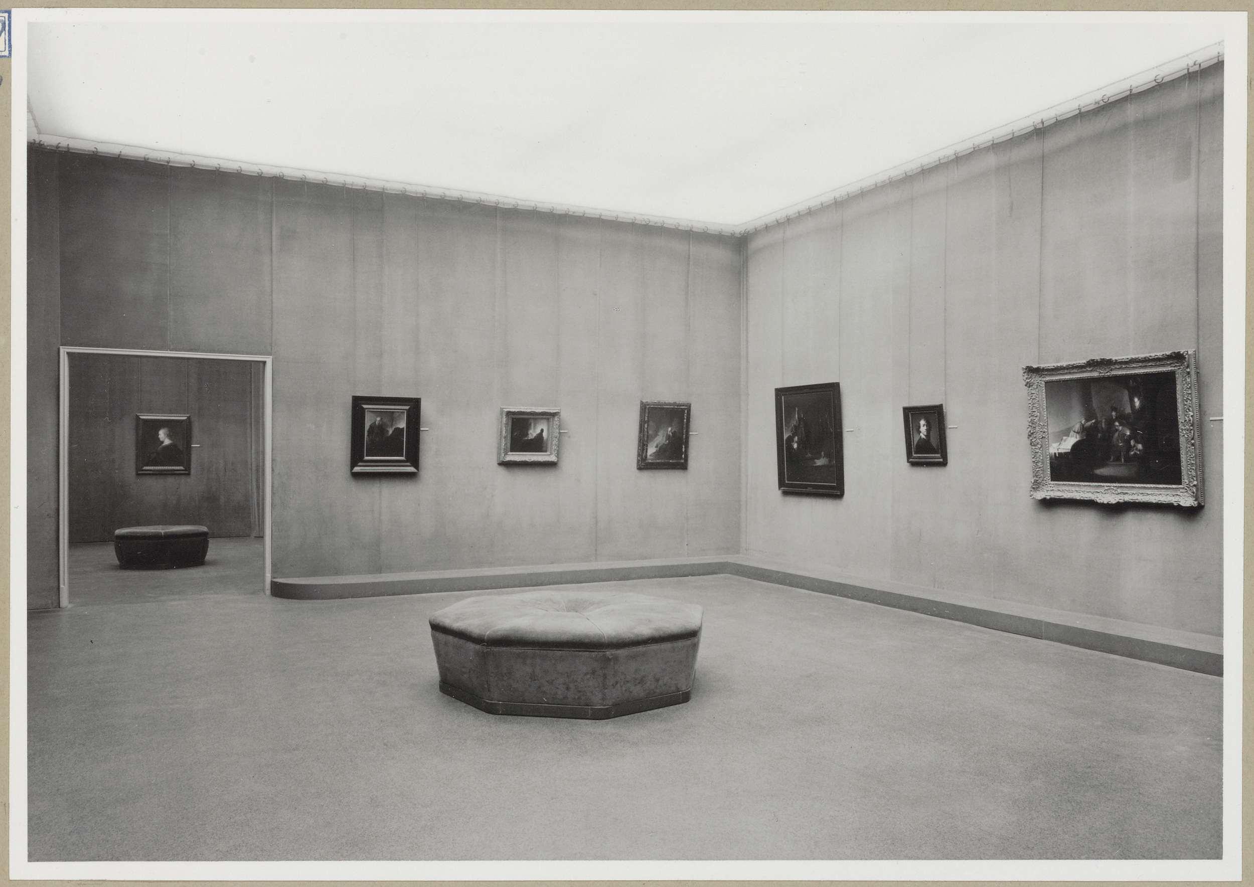 Zaal met zes schilderijen en een doorkijk naar een schilderij in een andere zaal links