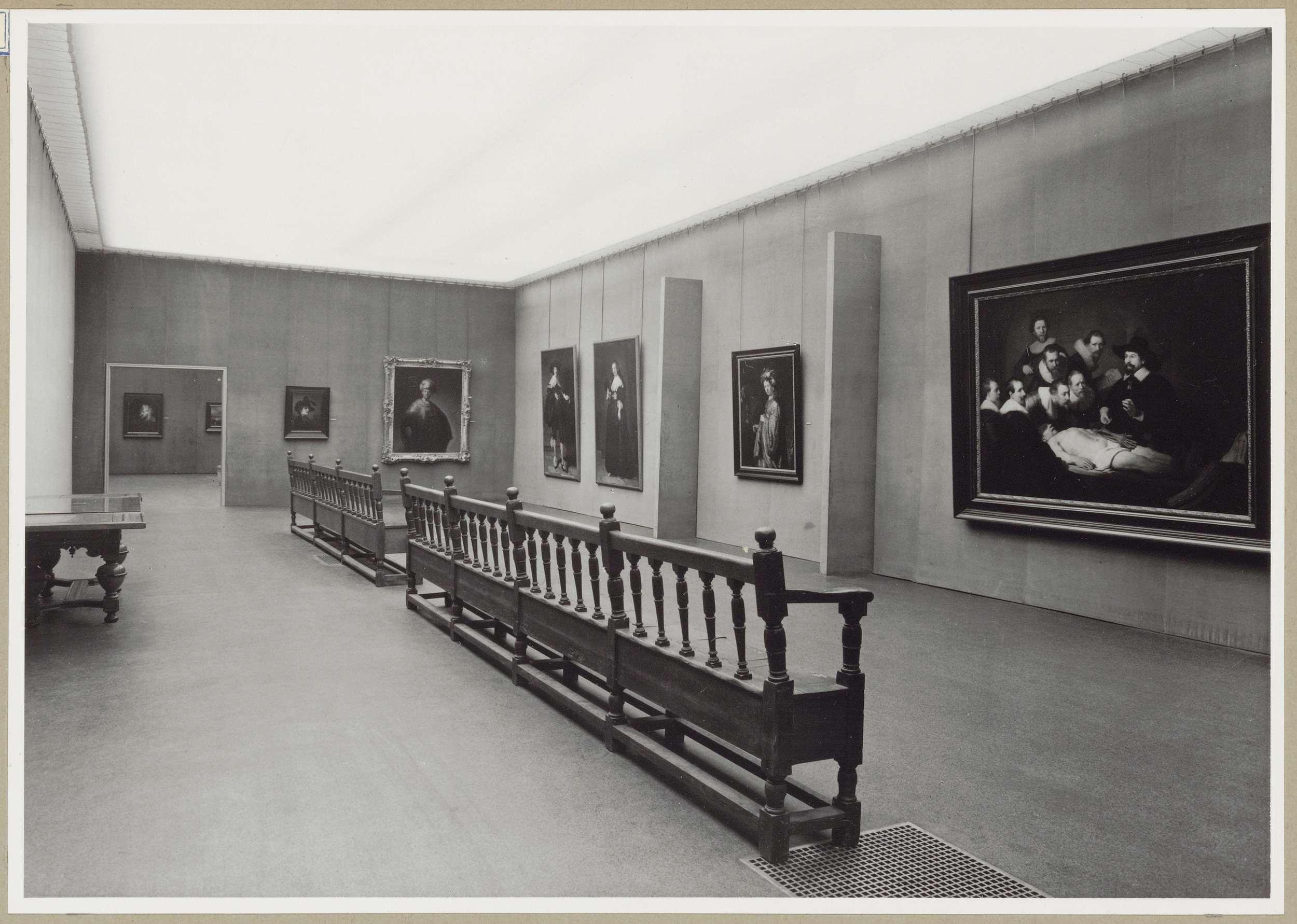 Zaal met portretten en twee scheidingswanden, linksachter een doorgang