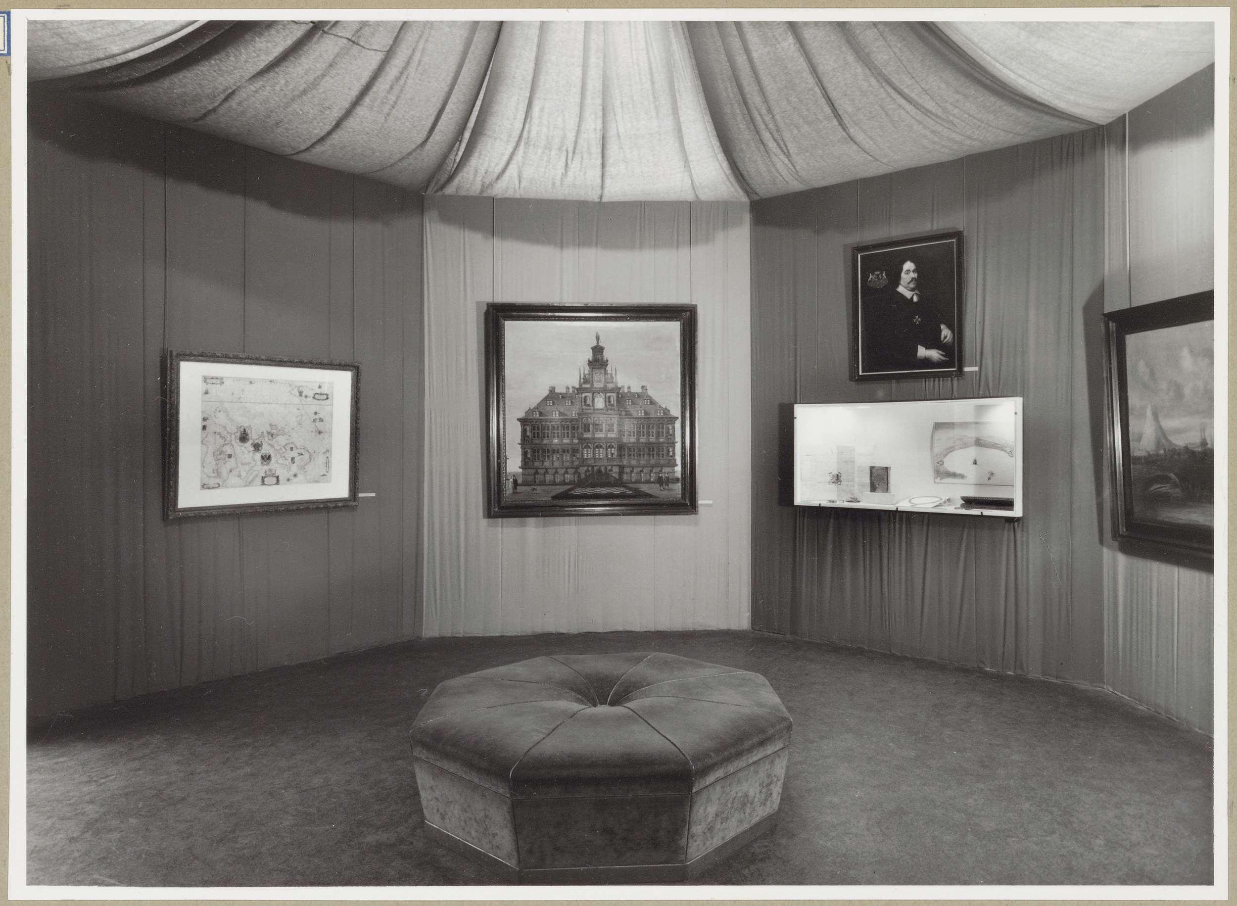Hoekzaal met rechts een portret boven een vitrine