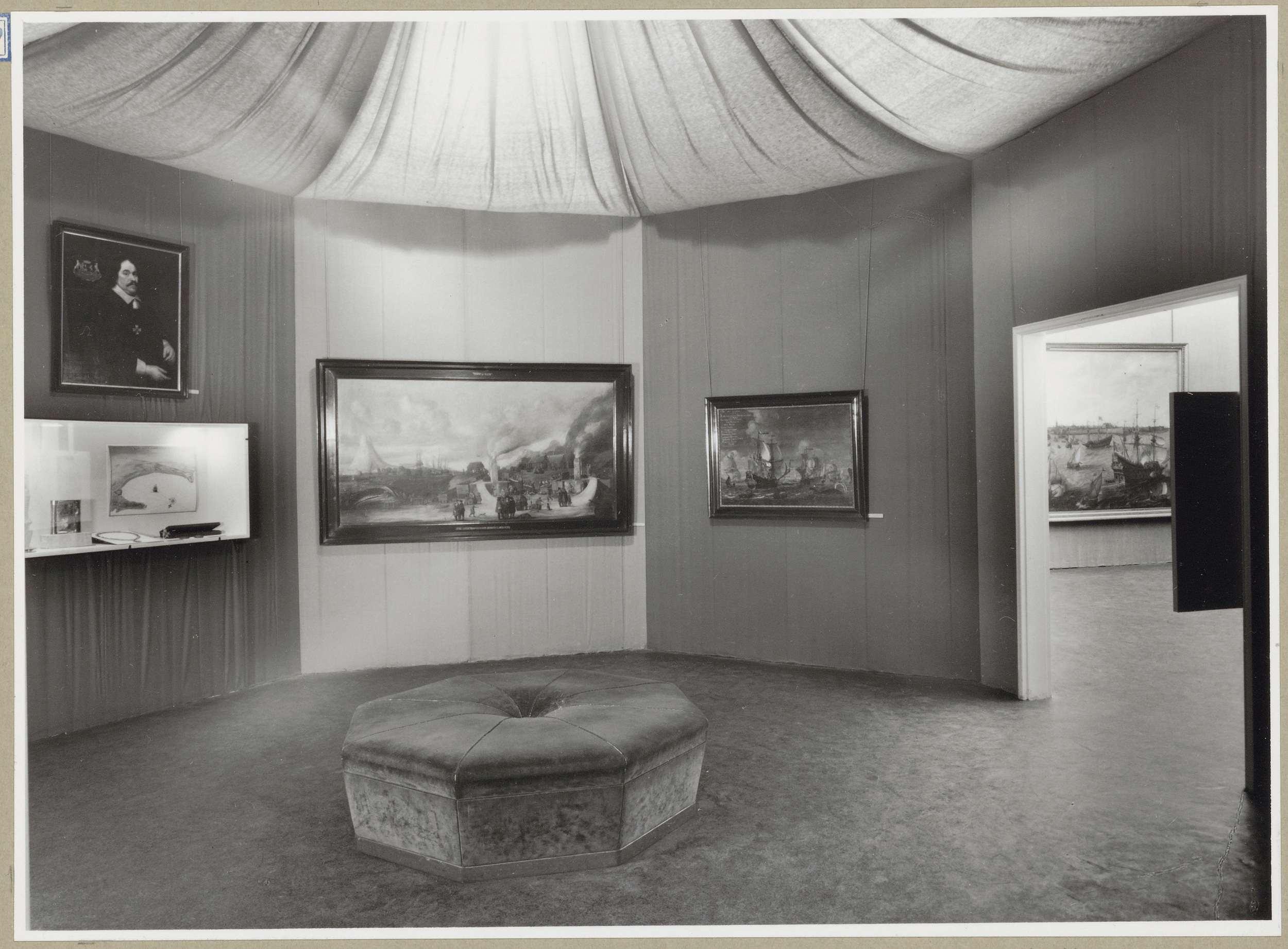 Zaal met links een portret boven een vitrine en rechts een doorgang