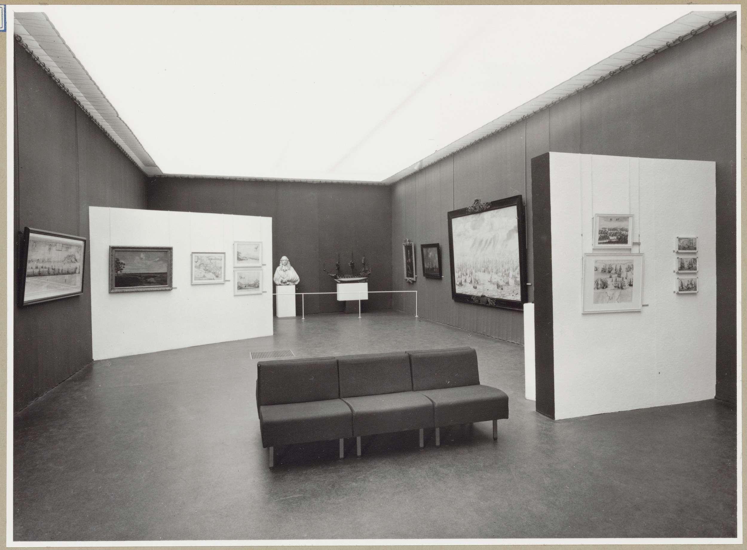 Zaal met twee scheidingswanden en achterin een borstbeeld