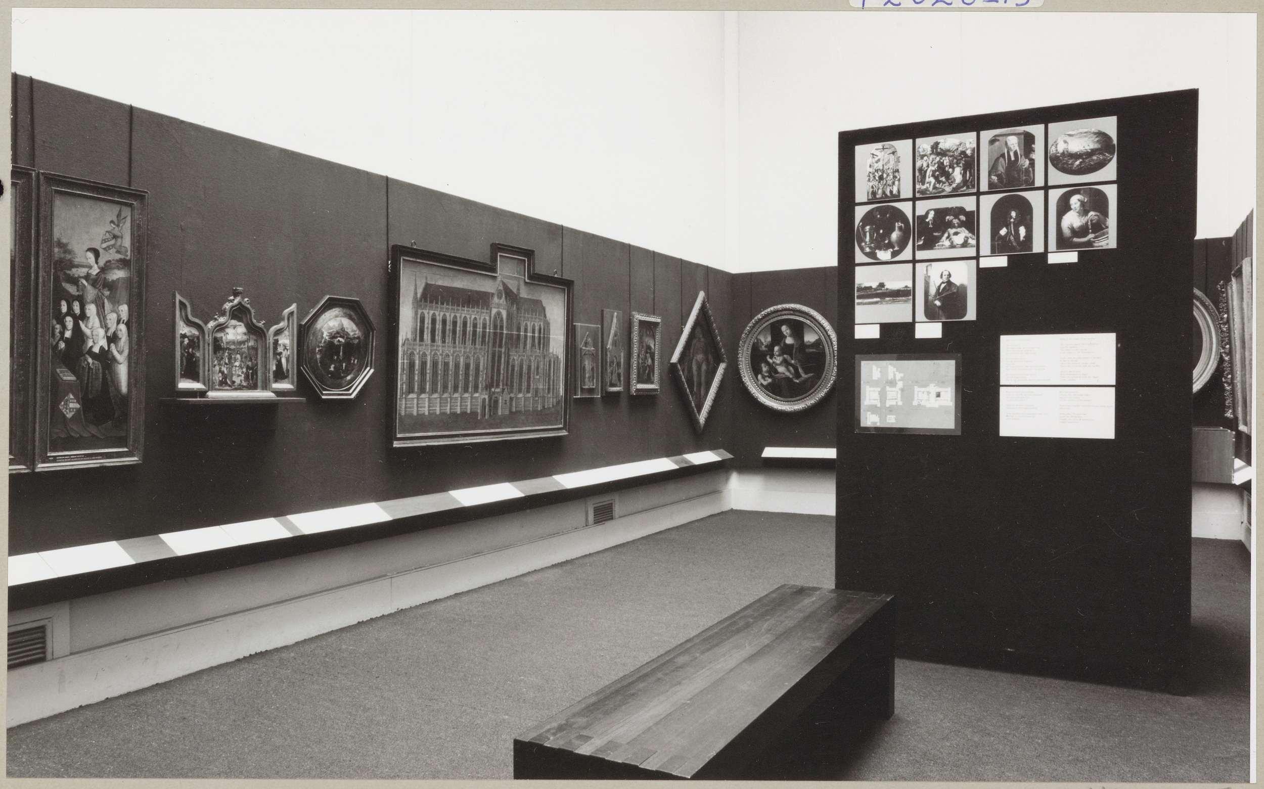 Kabinet van de Eregalerij met diverse objecten, een informatiepaneel en een bank voor bezoekers