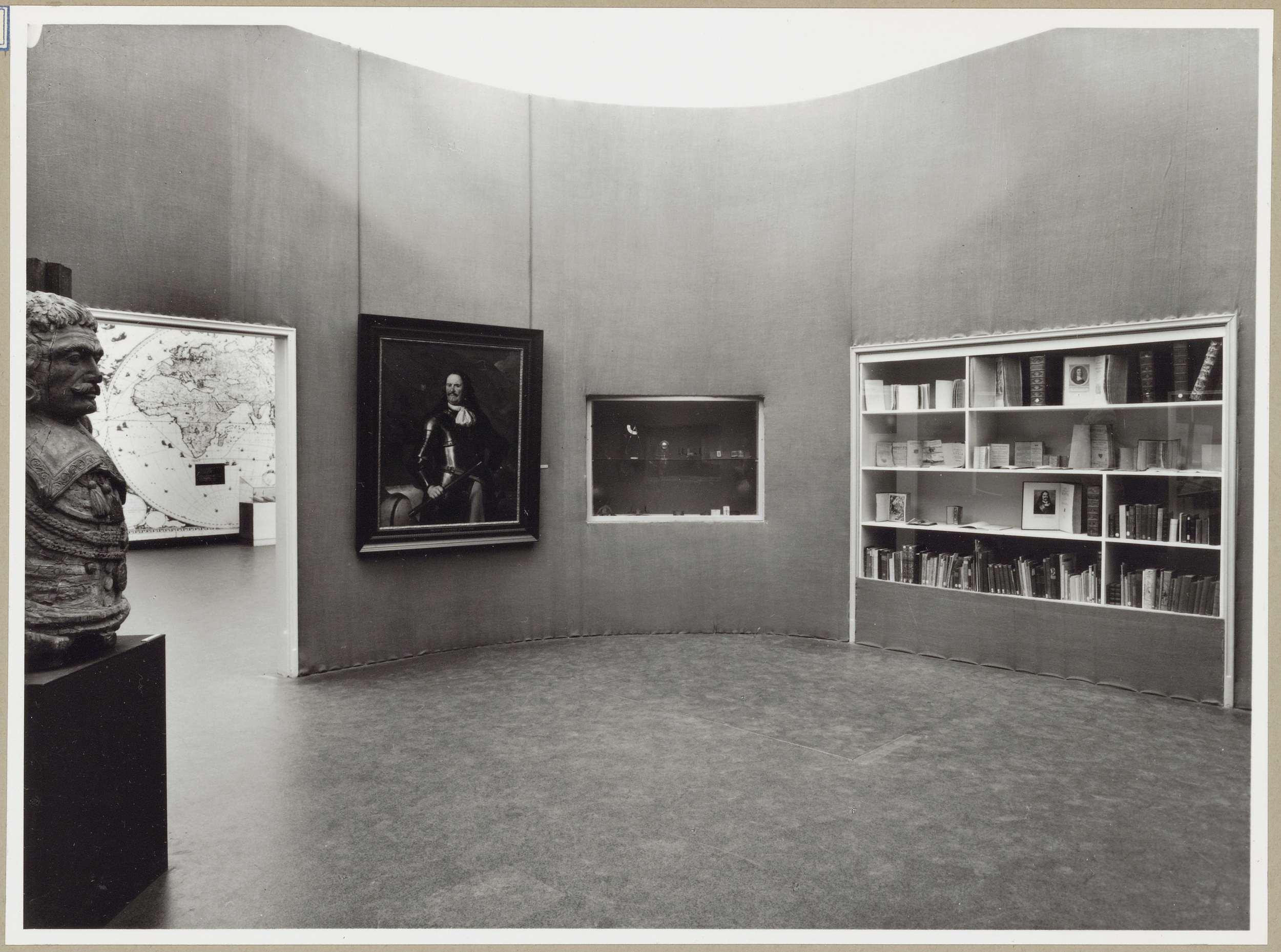 Zaal met een borstbeeld, een schilderij en twee vitrines in de muur rechts